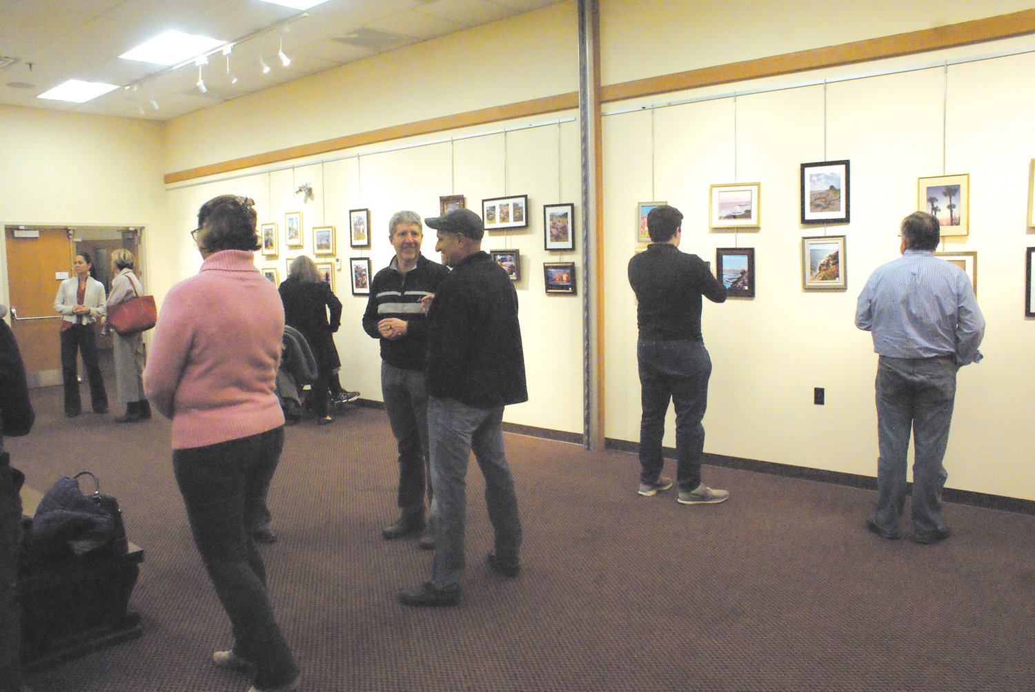 SHOWING HIS WORK: Terry Boylan (left) with his son Terrence and daughter-in-law Jennifer attended the Nov. 16 reception; Boylan is seated in front of his photography.